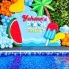 Kids pool party birthday decoration with tropical backdrop, balloons and popsicle props