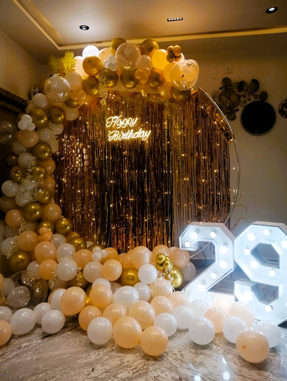 Elegant-gold-and-ivory-birthday-decoration-with-illuminated-backdrop