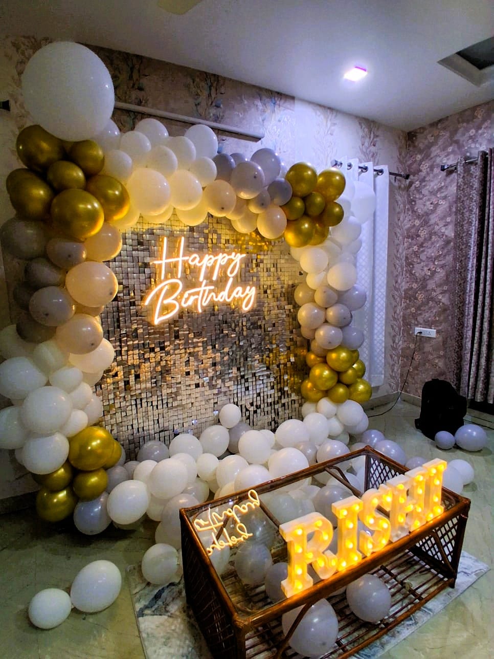 White and gold balloon birthday decoration with sequin backdrop and Happy Birthday neon sign