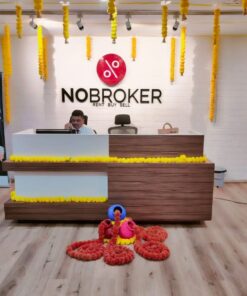 Office reception decorated with yellow garlands and suspended bell accents, with additional colourful floor styling
