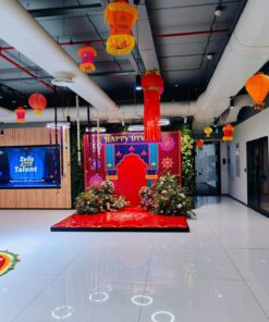 Office lobby customised with hanging festive lanterns, a red Happy Diwali photo backdrop and floral arrangements