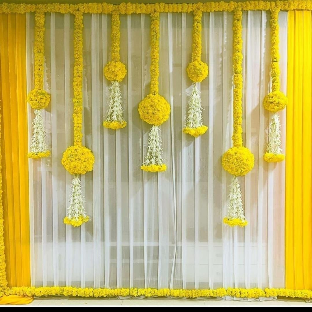 Alternative white sheer backdrop with yellow side drapes and suspended yellow-and-white floral hangings