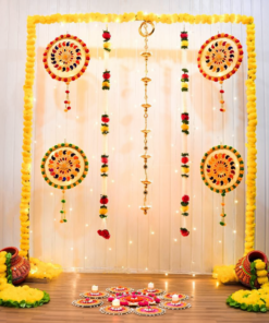 Yellow garland Diwali backdrop with a central diya hanging, four colourful circular accents, decorated pots and additional floor rangoli with LED candles